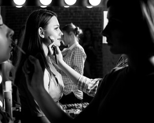 Plus size model get prepared to runway fashion show by make up artist. Black and white backstage...