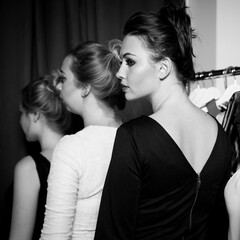 Fototapeta premium Plus size model get prepared to runway fashion show by make up artist. Black and white backstage concept