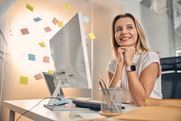 Charming young woman sitting at the table at work