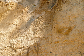 Background, a natural sandstone wall on a seaside cliff. Sandstone overlay