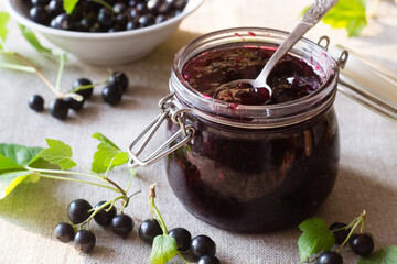 Black currant jam in jar with berries - obrazy, fototapety, plakaty