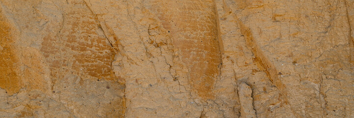 Background, a natural sandstone wall on a seaside cliff. Sandstone overlay