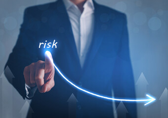 Businessman draw descending curve in graph to reduce corporate risk. 