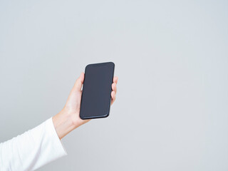 Woman holding smartphone with blank screen