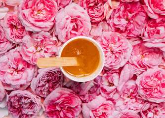 depilation and beauty concept - sugar paste or wax honey for hair removing flows down from wooden...