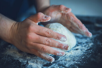 Cook hands soiled in flour knead wheat dough for bread. Home cooking.