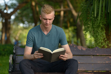 Fototapeta premium Young man with blond hair at the park outdoors