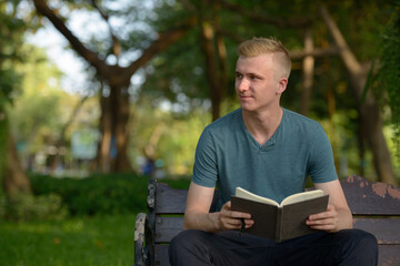 Fototapeta premium Young man with blond hair at the park outdoors