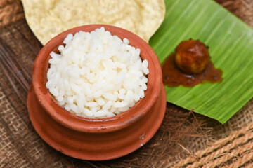 Rice porridge, Kanji, gruel in clay pot palm mat background Kerala South India .congee, rice soup,...