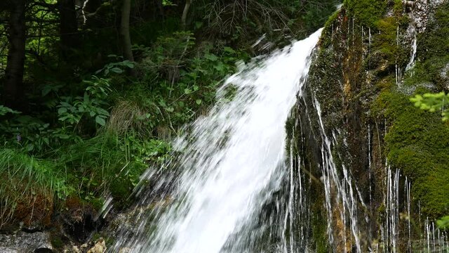 Mountain stream or waterfall flowing between rocks and stones. Foamy Valley Waterfall in Bucegi mountains accessible from Busteni town.