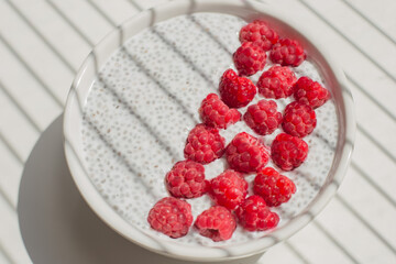 Chia pudding with coconut milk and fresh raspberries close-up.  Healthy vegan breakfast.  Clean eating concept.