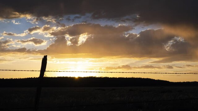 Time lapse of clouds, rain, and a golden sunset over a prairie