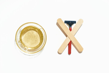 The razor VS wax. Razor against wax on the white background
