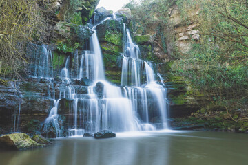 Fototapeta premium Majestic waterfall in deep forest. River forest scene. Wild, vivid vegetation. Beautiful landscape in Sintra, Portugal