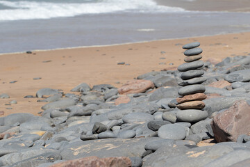 Concept of balance and harmony. Rocks on the coast of the Sea in the nature. Pile made of stone tower on the beach and blur background