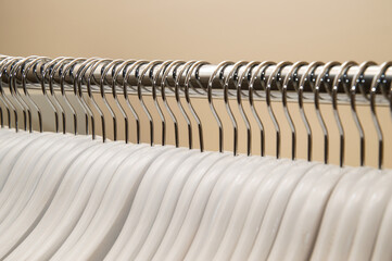 Close up, macro. A row of empty white hangers in the closet.
