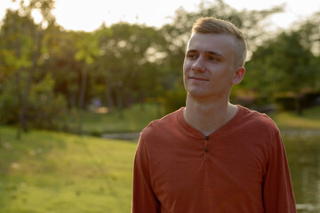 Young man with blond hair at the park outdoors