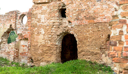 Fototapeta premium The ruins of the monastery in Biaroza, Belarus. The remains of the building. Brick destroyed walls. Red brick. Green grass around. 