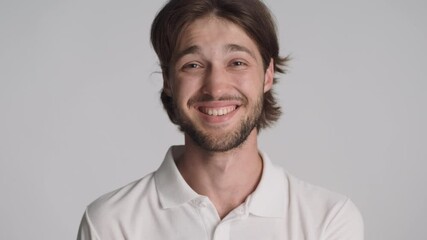 Portrait of attractive cheerful guy happily looking in camera over white background