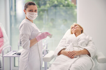 Obraz premium Attractive brunette doctor looking straight at camera