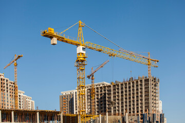 construction site with cranes against the blue sky