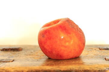 apple on a wooden table. rotten apple image
