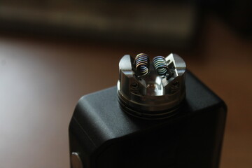 Vaping device with dual coil close up shot. Hi end rebuildable dripping atomizer. Nicotine...