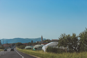 old Church in a European village, greenhouses, a village along the highway
