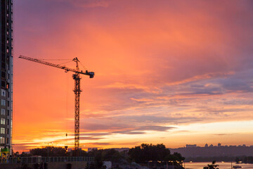 construction crane against the background of bright evening clouds	

