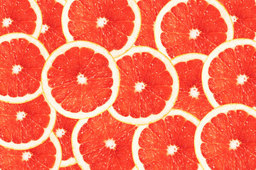 Bright red-orange background of round grapefruit lobules. Drawing for the surface of wallpaper, paper, advertising, decor.