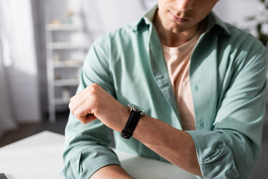 Cropped View Of Young Man Checking Time On Wristwatch At Home, Concept Of Time Management