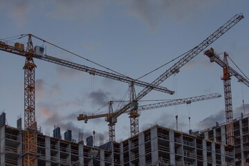 Construction site with cranes against the background of the evening sky