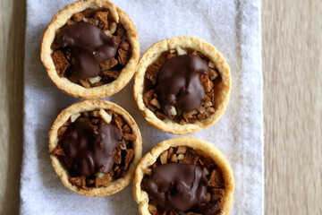 Pastry baskets filled with apples, almonds and dark chocolate. Top view.