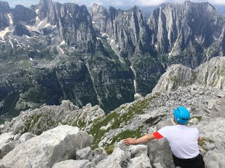 Prokletije, Albania: Hiker on the top of mountain watching the mountain peaks in the distance