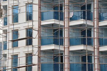building construction with scaffolding, windows office building for background
