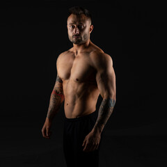 Fototapeta na wymiar Strong man. Bodybuilder on black background.