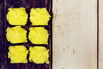 Square pieces of butter on a black and white wooden table.