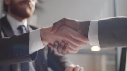 Close up selective focus shot of handshake of two multiethnic business partners in formalwear during meeting in the office - Powered by Adobe