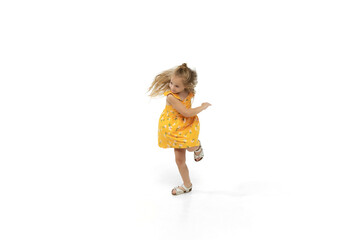 Happy child, little and emotional caucasian girl jumping and running isolated on white background. Looks happy, cheerful, sincere. Copyspace for ad. Childhood, education, happiness concept.