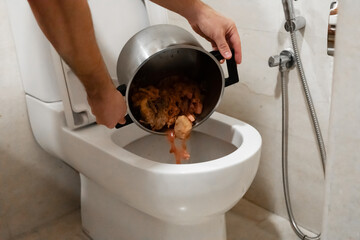 The girl pours a pot of soup into the toilet. Spoiled food