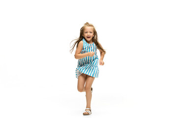 Happy child, little and emotional caucasian girl jumping and running isolated on white background. Looks happy, cheerful, sincere. Copyspace for ad. Childhood, education, happiness concept.