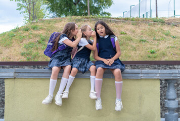 Three schoolgirls are sitting in the schoolyard. The problem of adaptation and communication at...
