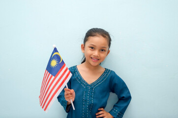 Malay girl holding Malaysia flag. Malaysia independence concept. Selective focus.
