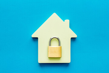 Fototapeta na wymiar Security concept - lock and house figure - on blue desk top-down