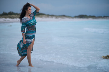 Sexy woman in a dress on the ocean coast