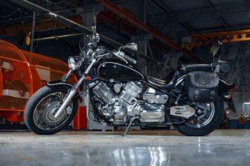 Obraz na płótnie Canvas Motorcycle standing in a dark hangar building