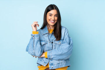 Young caucasian woman isolated on blue background laughing