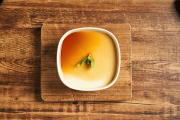 Wooden vintage tabletop with a bowl of milk pudding top view