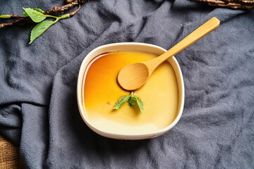 Homemade caramel custard pudding, mint in a vintage background