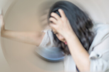 Vertigo illness concept. Blur woman hands on head felling headache dizzy sense of spinning...
